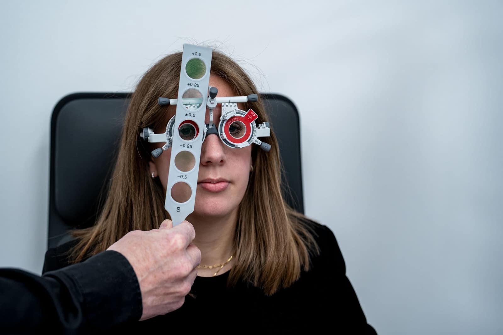 Kundin mit aufgesetzter Mess-/Prüfbrille beim Sehtest