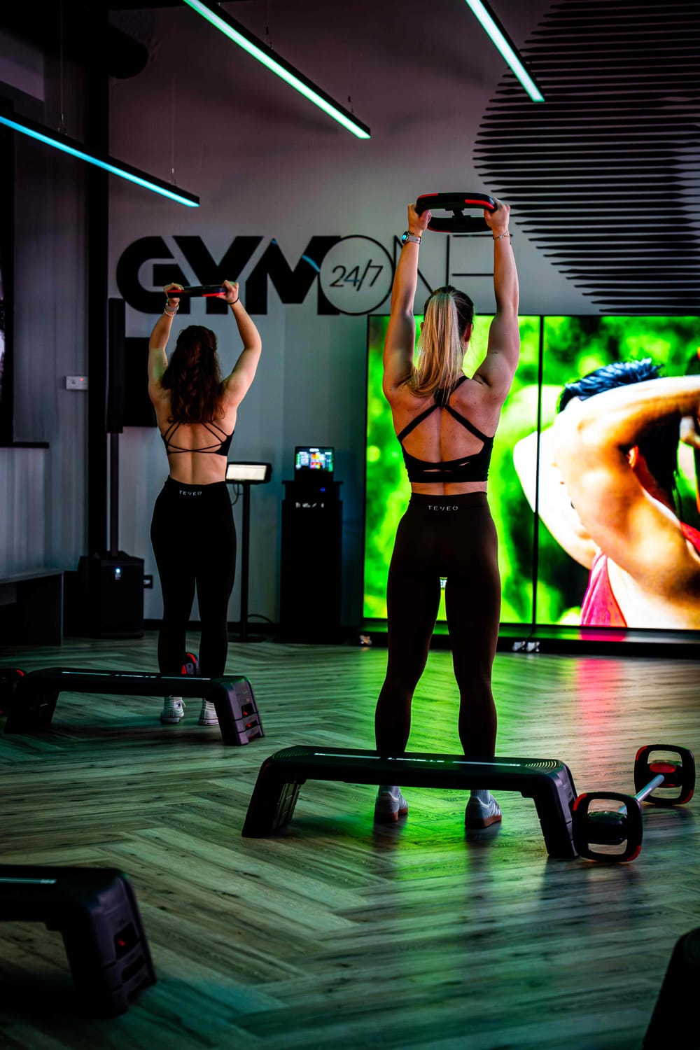LesMills Group-Fitness-Kurs im GymOne 24/7 Bitburg mit Teilnehmerinnen an Trainingsringen vor der GymOne-Wand