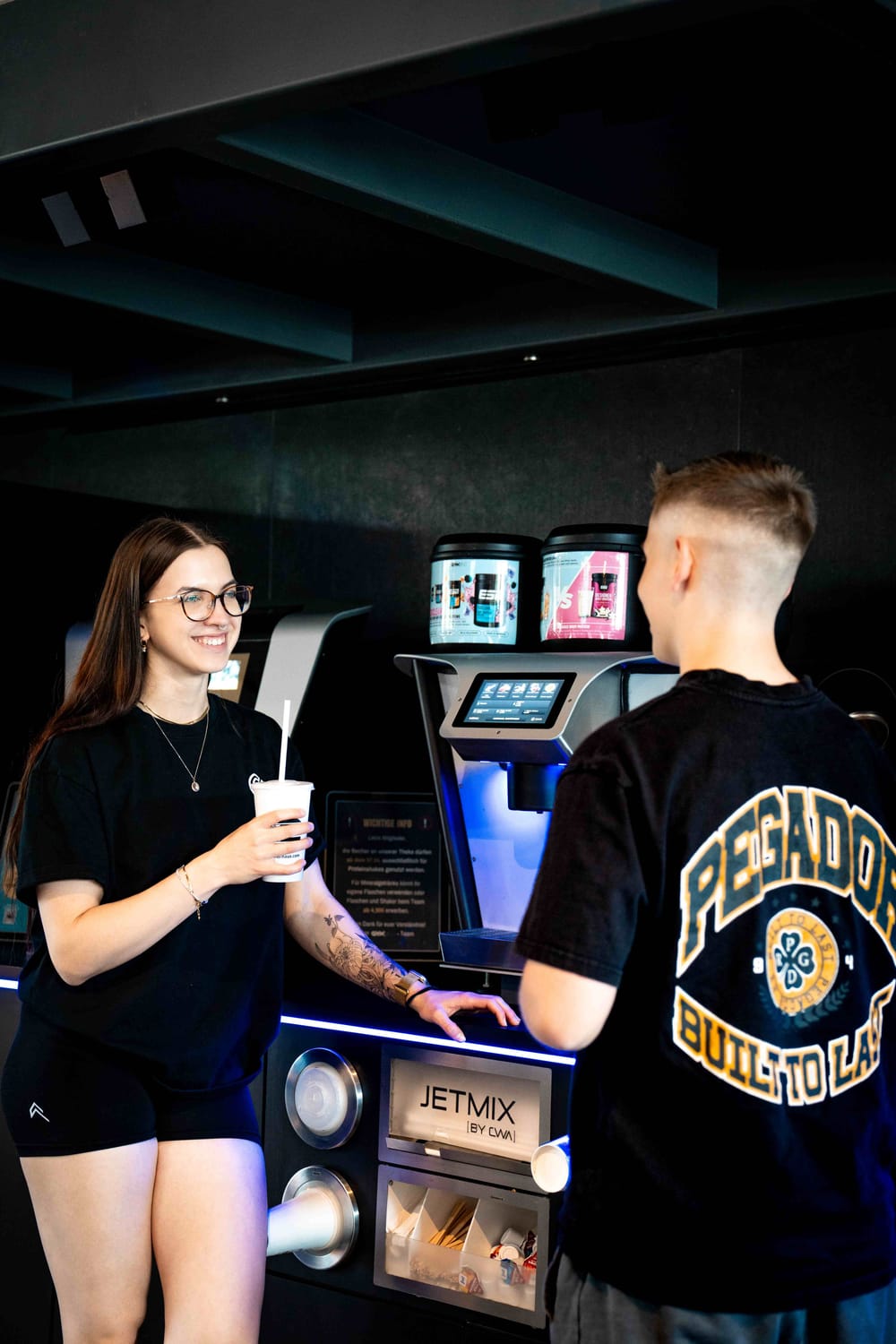 Mitglieder an der Shakebar des GymOne 24/7 Bitburg mit frisch zubereiteten Proteinshakes