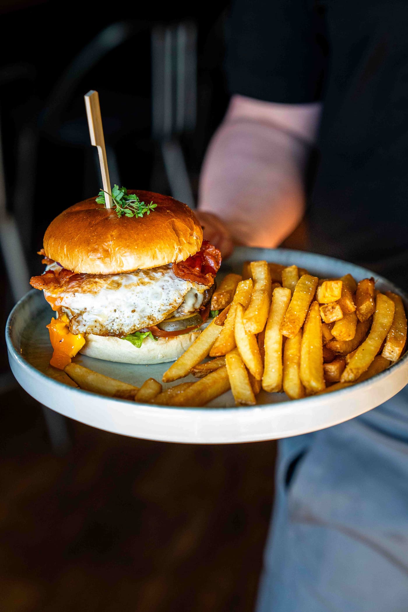 Burger mit Spiegelei und Bacon auf Brioche-Bun, serviert mit Pommes im Wirtshaus Moers